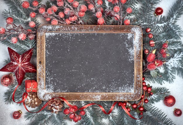 Tableau noir avec des décorations de Noël sur la neige, l'espace