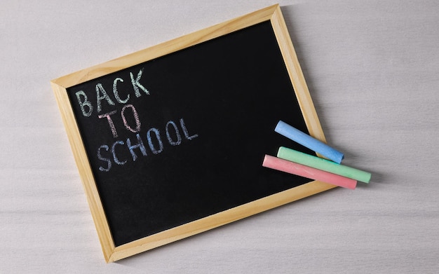 Un tableau noir d'école avec les mots Retour à l'école et de la craie à côté