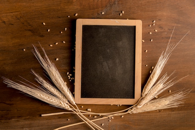 Tableau noir et épi de blé sur une table en bois marron