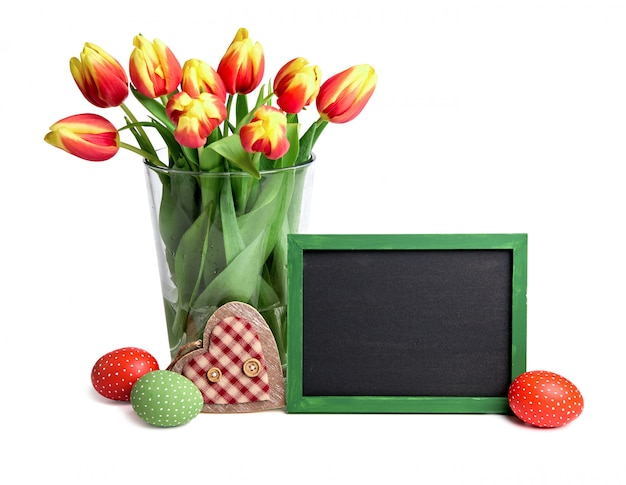Tableau noir avec espace de texte, bouquet de tulipes à rayures rouges dans un vase en verre,