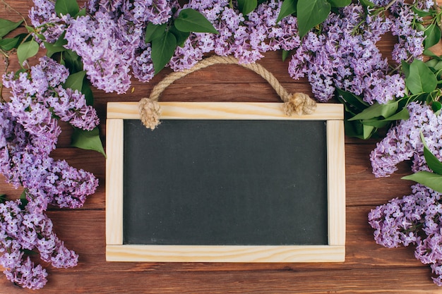 Photo tableau noir sur un fond en bois avec lilas