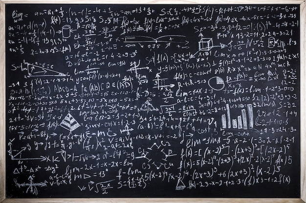 Tableau noir inscrit avec des formules scientifiques et des calculs en physique et en mathématiques