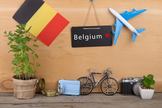 Tableau noir avec texte Belgique drapeau de la Belgique modèle d'avion petit vélo et valise appareil photo boussole