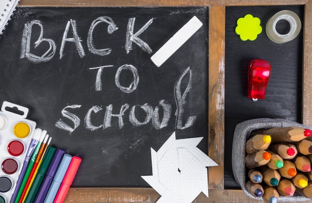 Photo tableau noir et texte de retour à l'école fournitures de bureau scolaires colorées