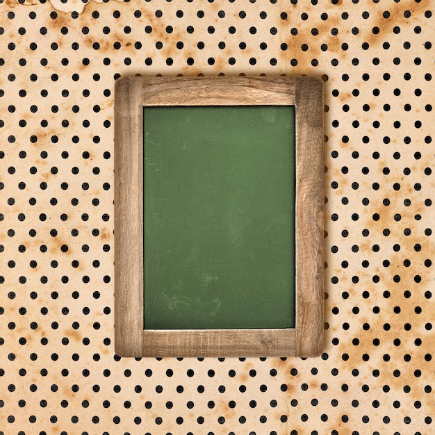 Tableau vert antique avec cadre en bois sur fond vintage à pois