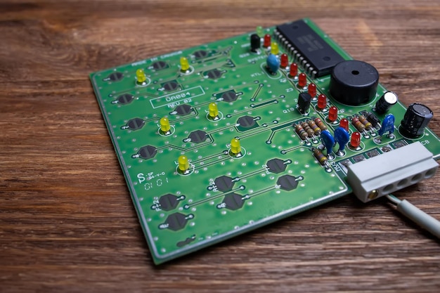 Un tableau vert avec des transistors se trouve sur une table en bois