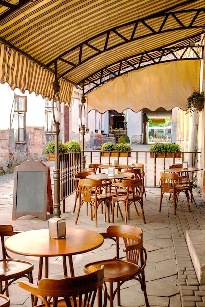 Tables et chaises en bois sous un auvent près du vieux café