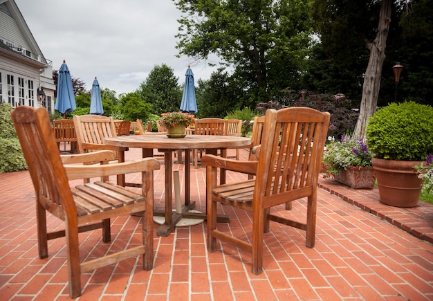 Tables et chaises de patio en teck sur terrasse en brique