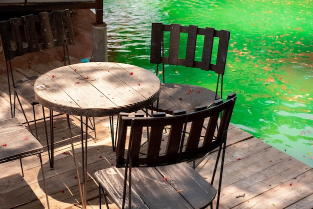 Tables Et Chaises Sont Disposées Au Bord De La Piscine Dans Le Jardin Dînatoire Au Milieu D'une Ambiance Agréable Et Ombragée