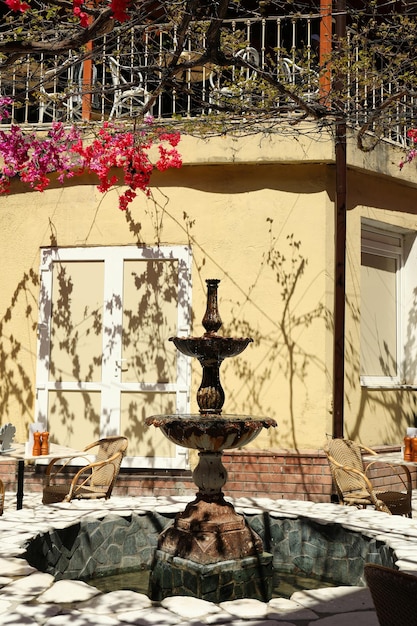 Tables de fleurs de fontaine avec chaises dans un café en plein air