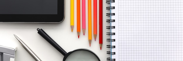 Tablet pc et ensemble de crayon sur la table de travail agrandi. Recueillir l'enfant au concept de l'école