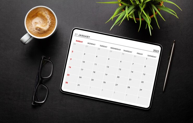 Photo tablette avec application calendrier tasse à café et fournitures de bureau