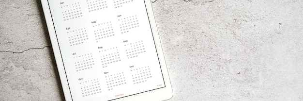 Photo une tablette avec un calendrier ouvert pour l'année 2021 sur un gris