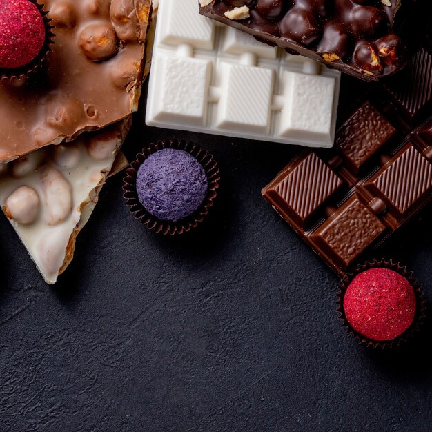 Tablette de chocolat, morceaux de chocolat noir écrasés et noix. Bonbons au chocolat praliné. Copiez l'espace.