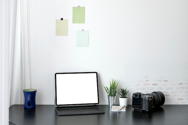 Tablette à écran blanc avec clavier magique sur table supérieure en bois noir