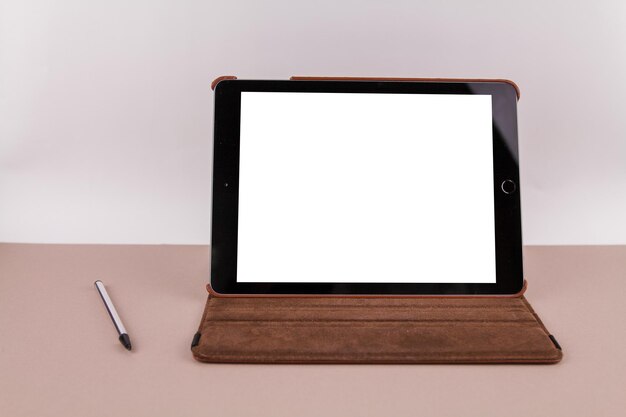 Tablette avec écran blanc sur la table de bureau et stylet près