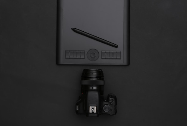 Photo tablette graphique avec stylet, appareil photo sur fond noir. vue de dessus