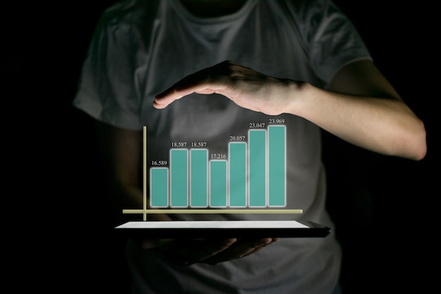 Tablette De Holding Homme D'affaires Et Montrant Un Hologramme Virtuel Croissant De Statistiques