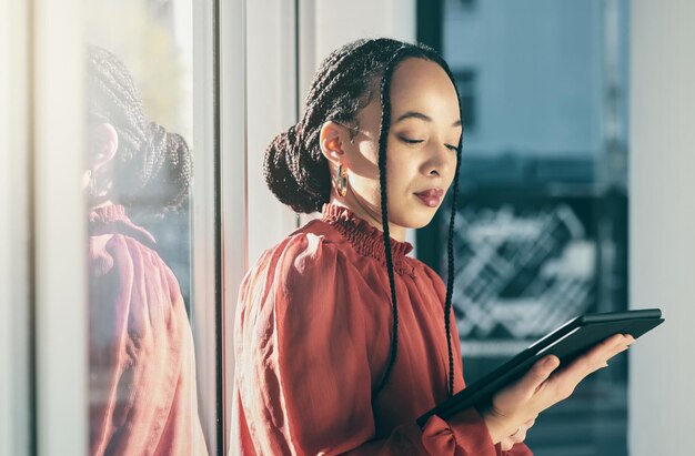 Tablette Internet et une femme d'affaires noire dans son bureau travaillant en ligne pour la planification de l'horaire ou du calendrier Fenêtre technologique et recherche avec un employé de l'entreprise lisant des données ou des informations