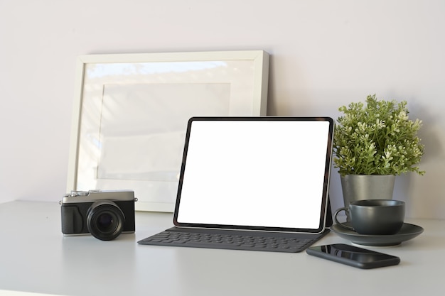 Tablette de maquette de bureau à domicile avec un clavier intelligent sur une table de travail blanche minimale.