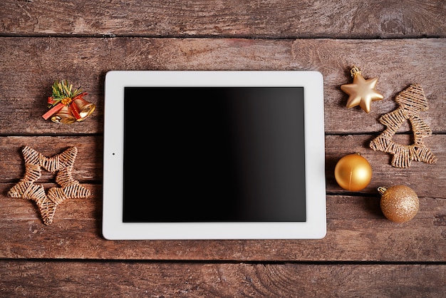 Tablette numérique et décor de Noël sur table en bois