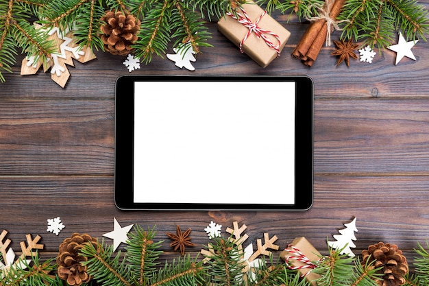 Tablette numérique avec décorations de Noël rustiques pour la présentation de l'application. vue de dessus