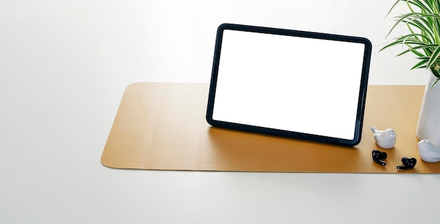 Tablette numérique à écran blanc vierge et gadget sur tableau blanc avec espace de copie.