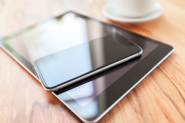 Tablette numérique et téléphone intelligent sur une table en bois