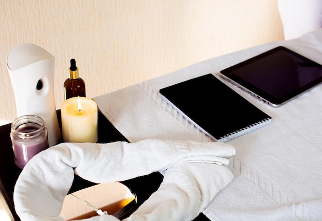 une tablette et un ordinateur portable se trouvent sur la table pour enregistrer les clients pour un massage attributs de massage
