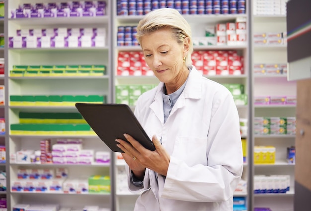 Tablette de pharmacie et femme pharmacienne pour la gestion des produits, recherche de stock et application de données d'inventaire, technologie numérique, logistique de détail et médecin senior ou personne disposant d'un logiciel de médecine