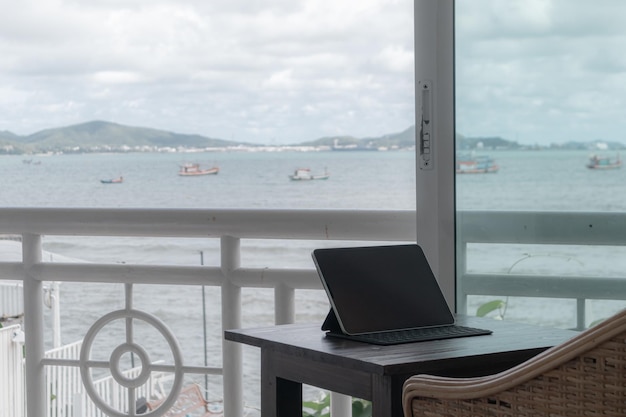 Tablette sur table au balcon de la chambre d'hôtel avec vue sur la mer