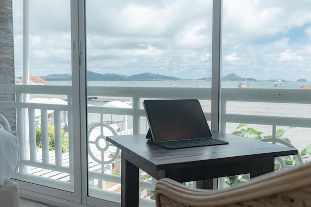 Tablette sur table au balcon de la chambre d'hôtel avec vue sur la mer