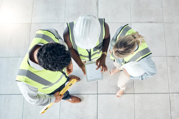 Photo tablette de travail d'équipe ou travailleurs de la construction d'ingénieurs travaillant en collaboration sur un projet de construction sur un chantier