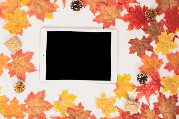 Tablette vierge vue de dessus décorée avec des feuilles d'automne d'érable coloré et des coffrets cadeaux