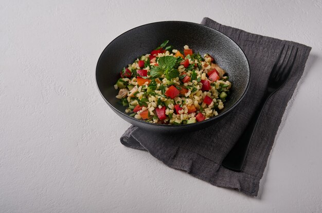 Taboulé de salade traditionnelle orientale à base de boulgour ou de couscous viande de volaille persil menthe dans l'obscurité