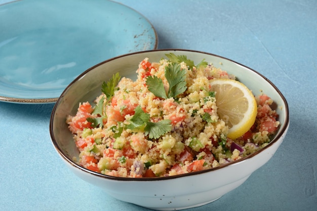 Photo taboulé une salade végétarienne de cuisine du moyen-orient avec des tomates persil hachées, de l'oignon à la menthe et du boulgour et assaisonné avec du jus de citron à l'huile d'olive