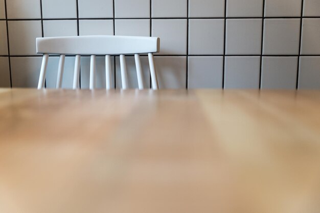 Tabouret blanc vide devant la tuile blanche