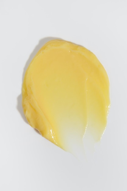 Tache de crème de beauté jaune sur fond blanc Texture du produit de soin cosmétique