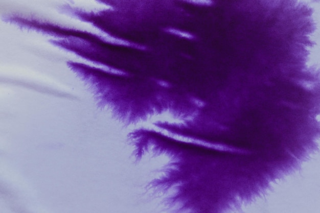 Tache d'encre violette sur une feuille de papier blanc macro