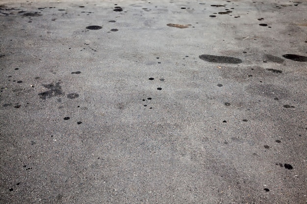 Taches d'huile de voiture sur une route asphaltée