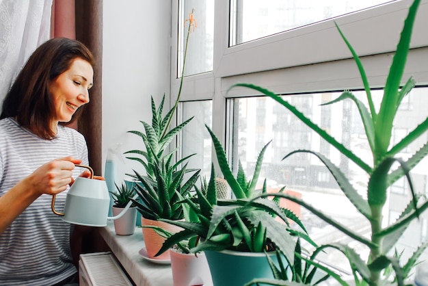 Tâches ménagères une femme arrose des fleurs faites maison à la maison