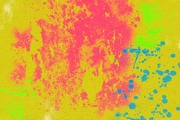 Taches de peinture rose et bleue sur papier texturé jaune