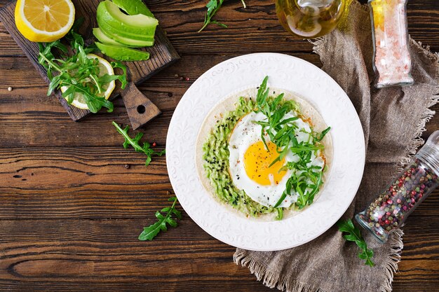 Tacos au guacamole, œuf au plat et roquette. Nourriture saine. Petit déjeuner utile. Mise à plat. Vue de dessus