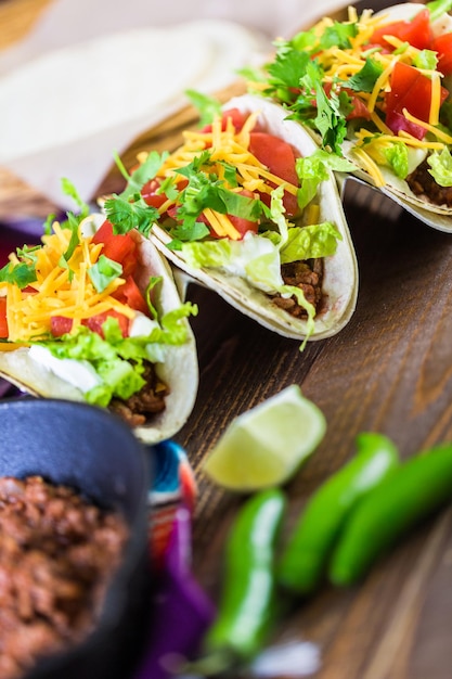 Tacos de boeuf haché avec laitue romaine, tomates en dés et fromage cheddar râpé.