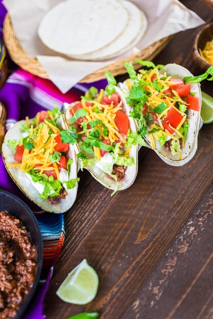 Tacos de boeuf haché avec laitue romaine, tomates en dés et fromage cheddar râpé.