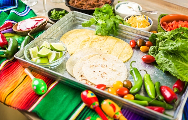 Tacos de boeuf haché avec laitue romaine, tomates en dés, radis et fromage cheddar râpé.