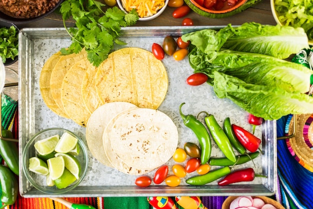 Tacos de boeuf haché avec laitue romaine, tomates en dés, radis et fromage cheddar râpé.