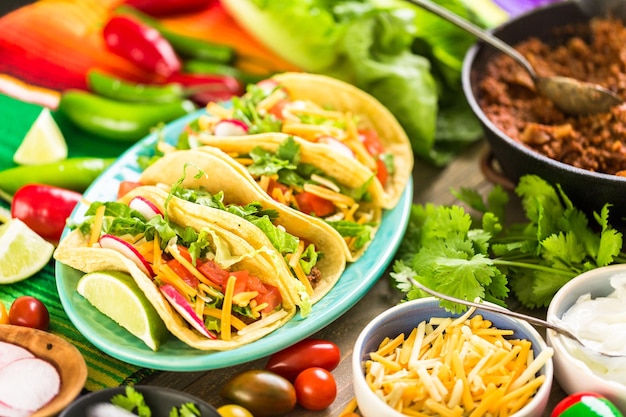 Tacos de boeuf haché avec laitue romaine, tomates en dés, radis et fromage cheddar râpé.