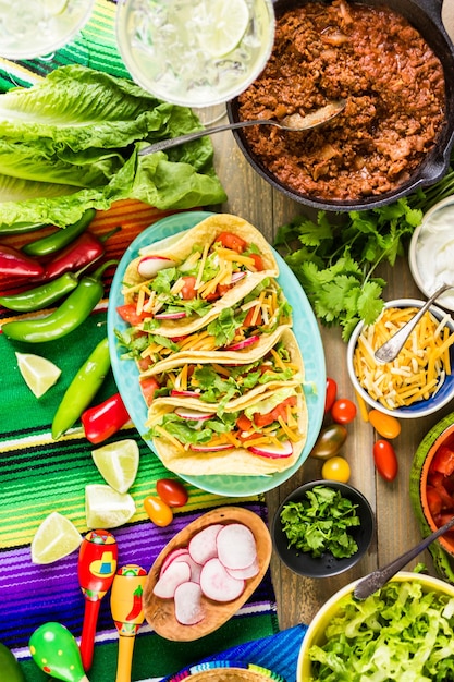 Tacos de boeuf haché avec laitue romaine, tomates en dés, radis et fromage cheddar râpé.