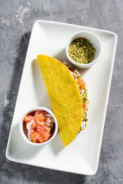 Tacos de maïs avec mayonnaise au saumon et pistaches sur une table en béton